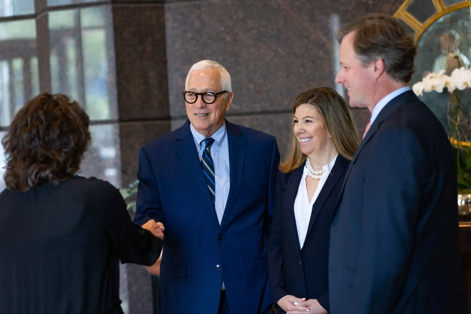 Attorneys greeting client in lobby